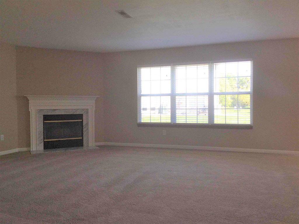 A room with a fireplace and a window.