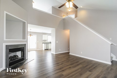 a living room with a fireplace and a ceiling fan