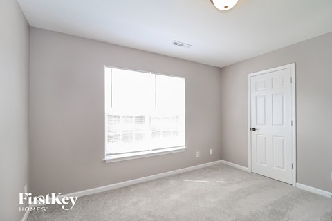 a bedroom with a large window and a white door