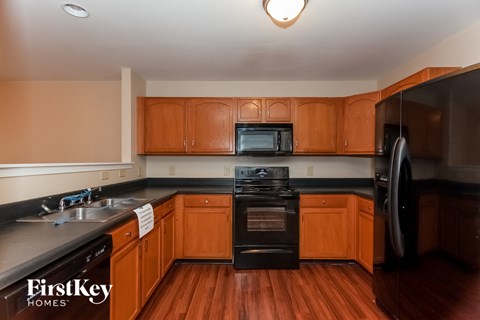 A kitchen with wooden cabinets and black appliances.
