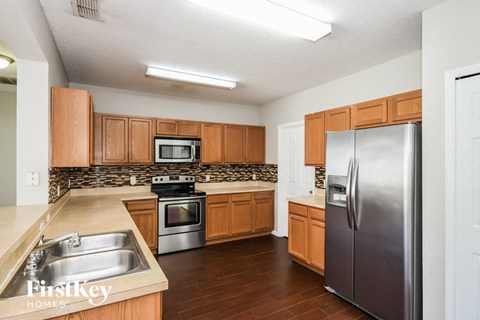 a kitchen with wooden cabinets and stainless steel appliances