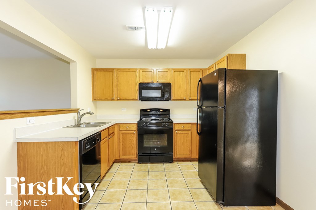 a kitchen with black appliances and wooden cabinets