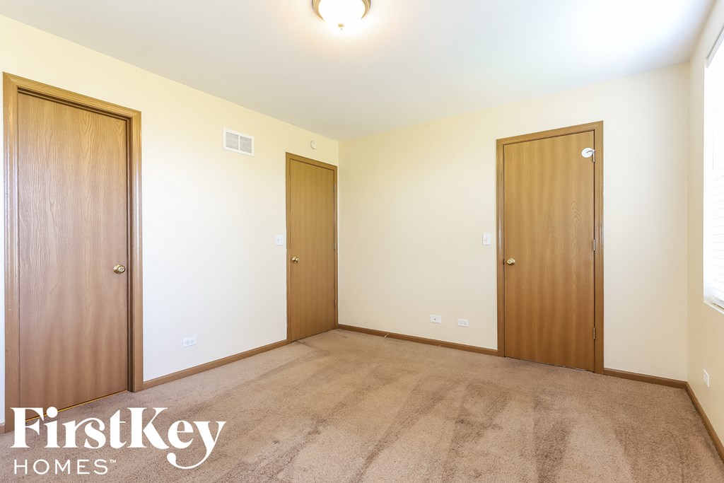 a bedroom with two doors and a carpeted floor