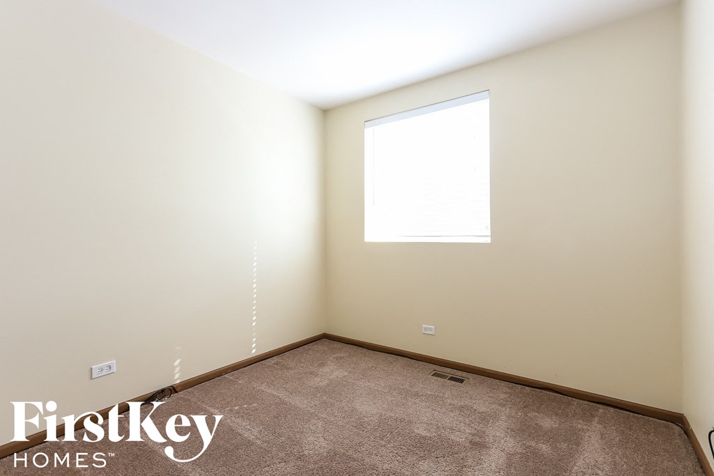 a small room with a window and a carpet