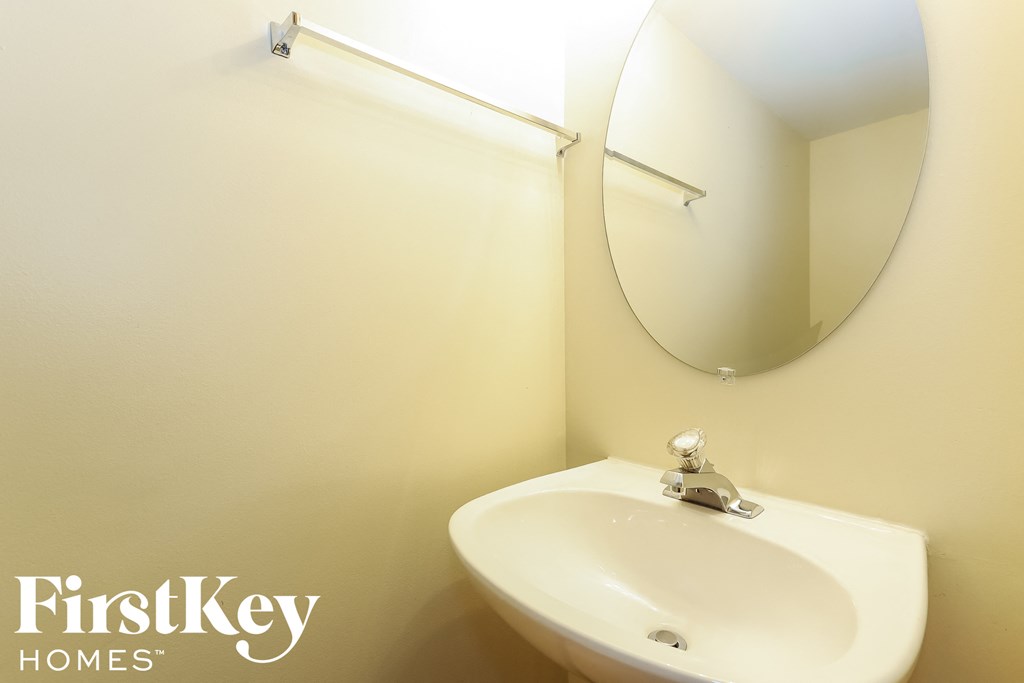 a small bathroom with a white sink and a mirror