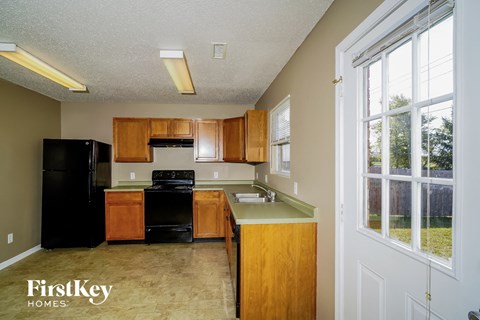 a kitchen with wood cabinets and black appliances and a window