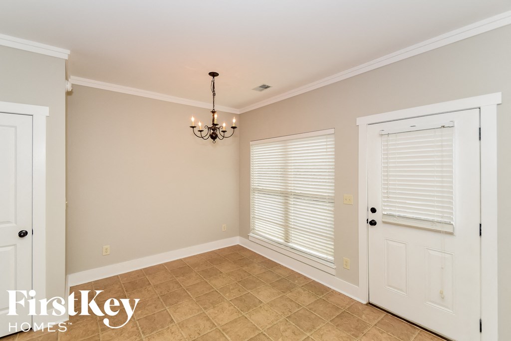 a dining room with a door and a chandelier