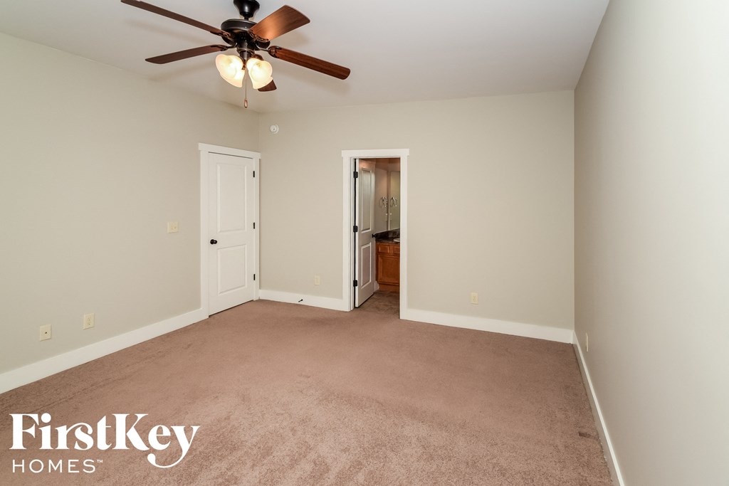a bedroom with a carpeted floor and a ceiling fan