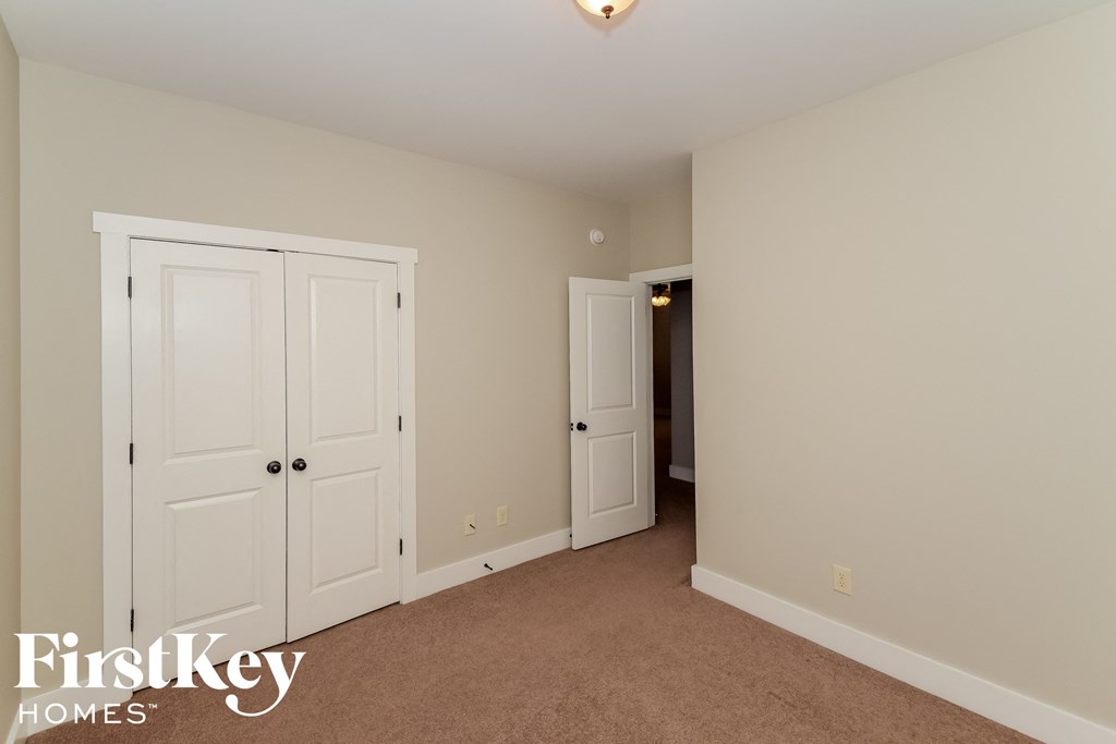 a bedroom with two closets and a door to a hallway