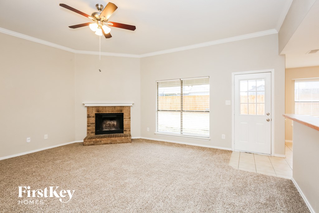 a living room with a fireplace and a ceiling fan