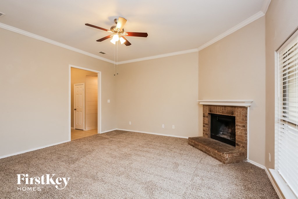 a living room with a fireplace and a ceiling fan
