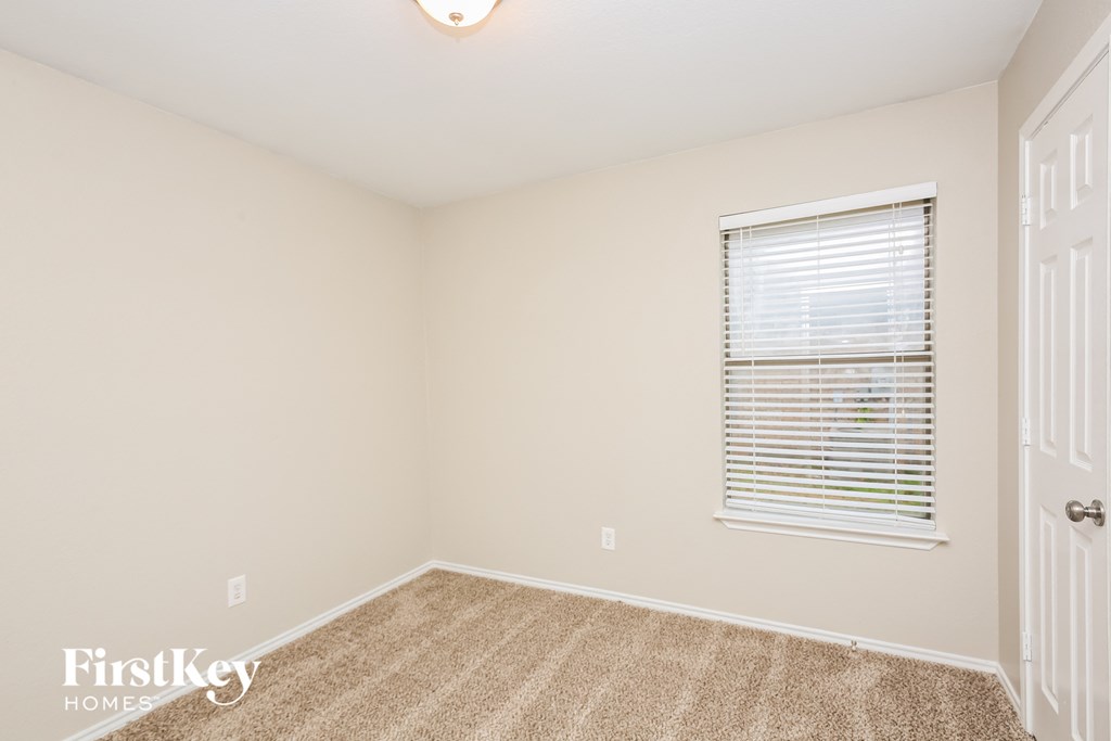 a spacious room with carpet and a window