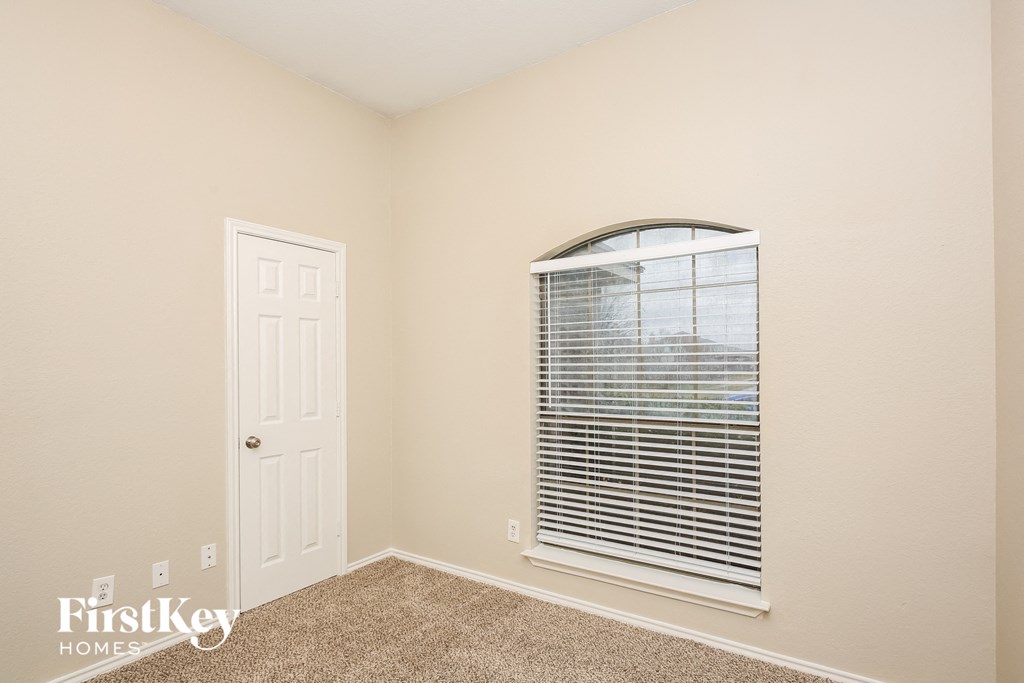 a bedroom with a large window and a white door
