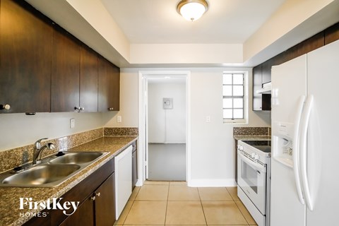 A kitchen with a sink, refrigerator, and oven.
