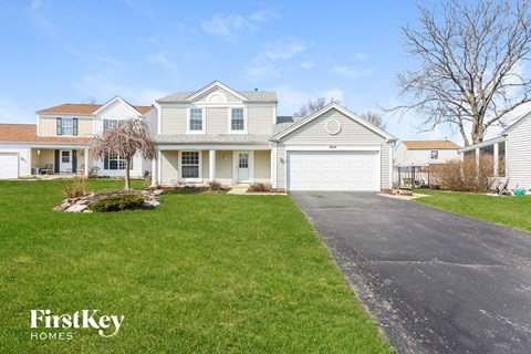 a white house with a driveway and a lawn