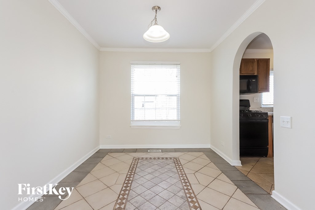 an empty kitchen with a large window and tiled flooring