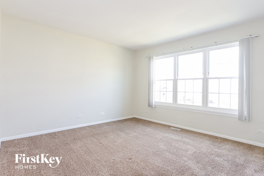 a bedroom with a carpeted floor and two windows
