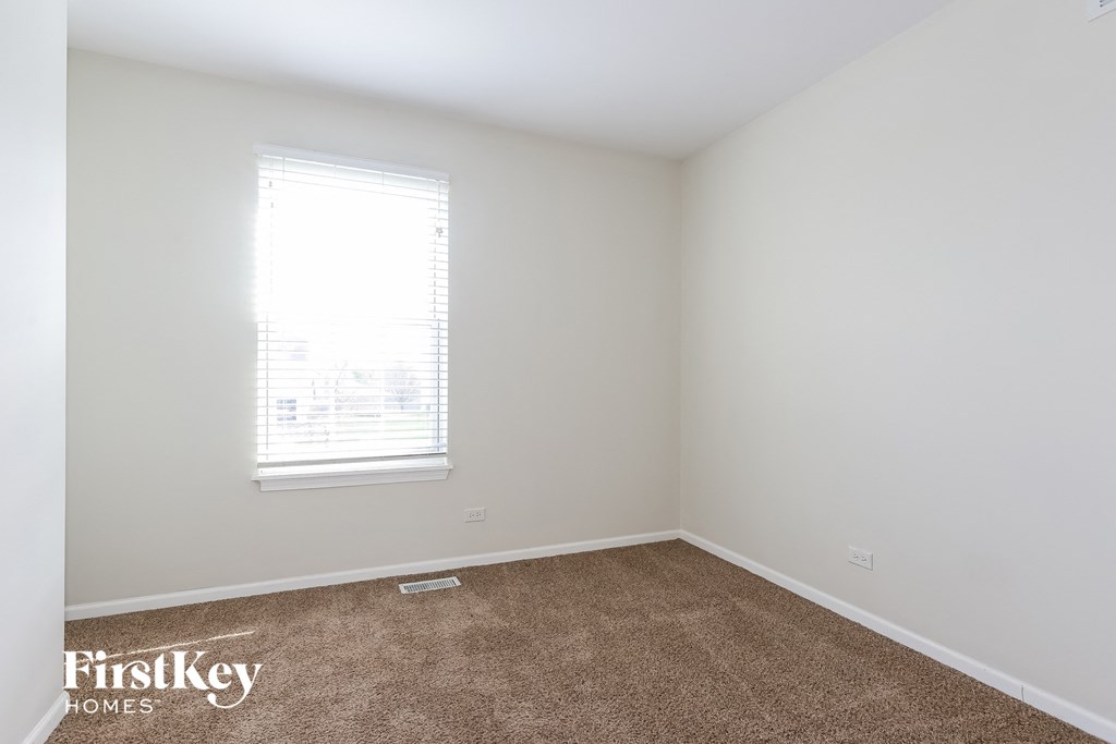 a bedroom with a carpeted floor and a window