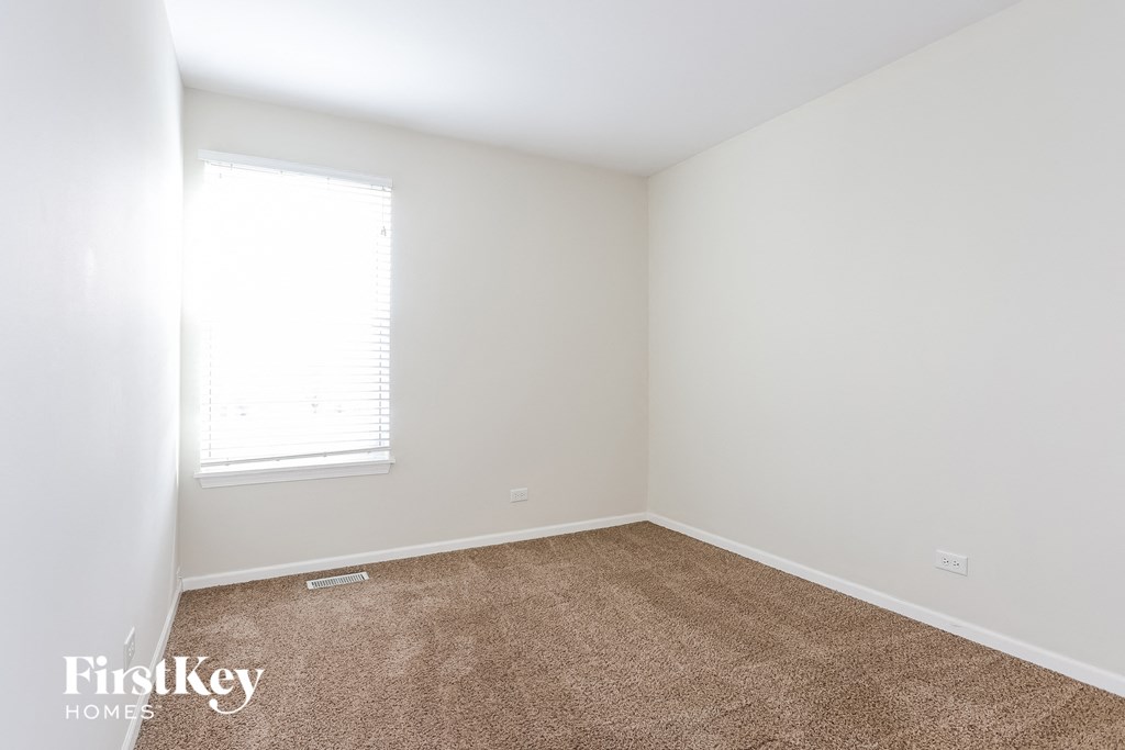 a bedroom with a carpeted floor and a window