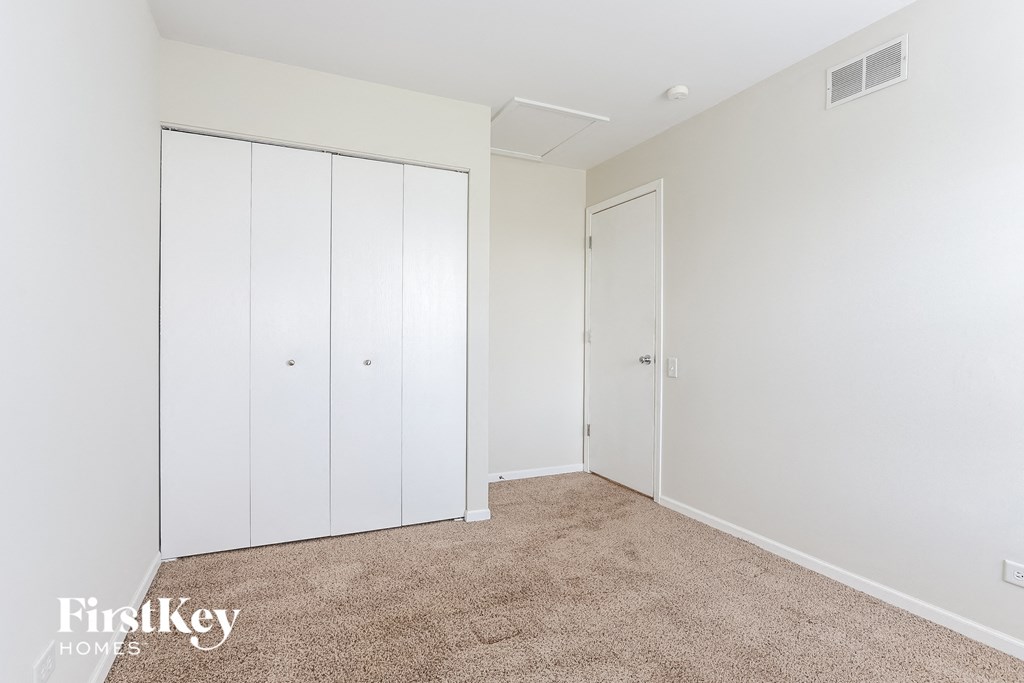 a bedroom with two closets and a carpeted floor