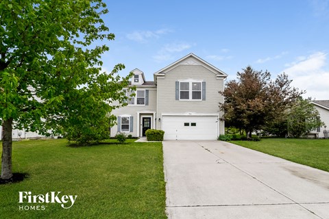 A house with a white garage door is for sale by FirstKey Homes.