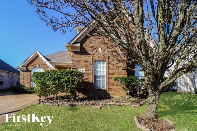 A brick house with a tree in front of it.