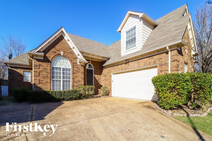 A brick house with a garage door and a window.