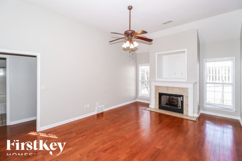 A room with a fireplace and a ceiling fan.