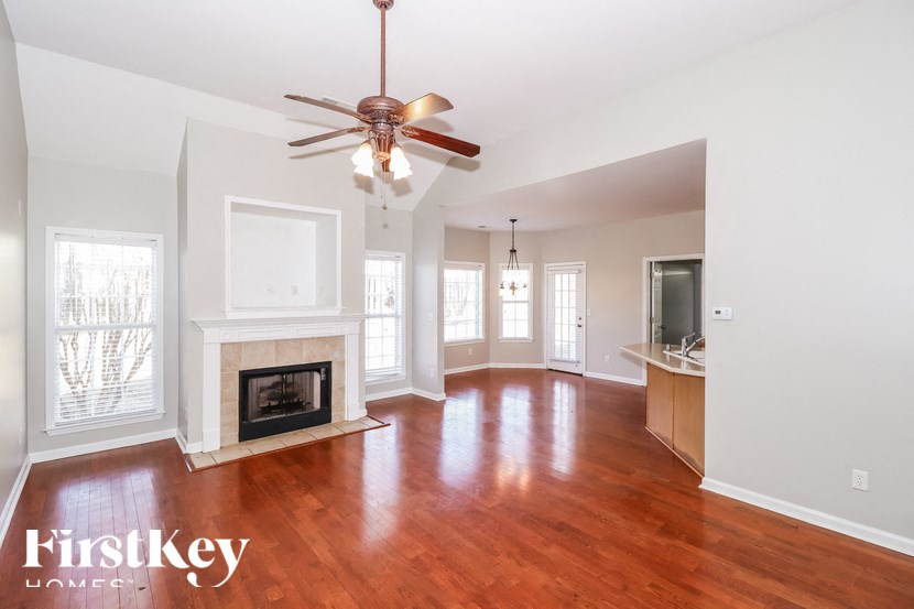 A spacious living room with wood floors and a fireplace.