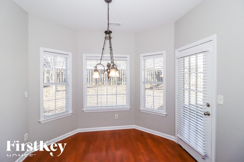 A room with a wooden floor and a chandelier hanging from the ceiling.