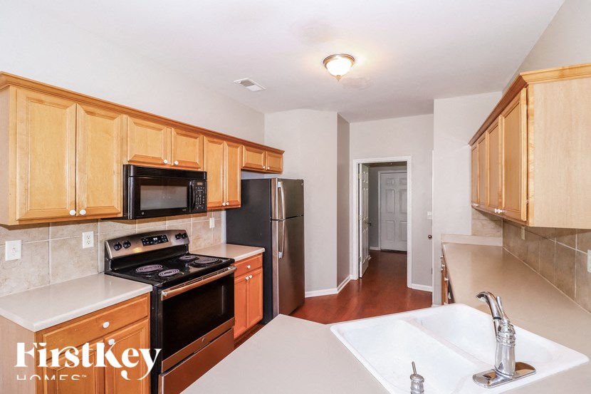 A kitchen with wooden cabinets and a black stove top oven.