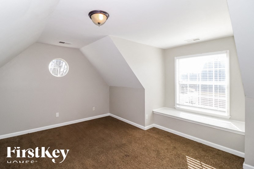 A room with a window and a carpet on the floor.