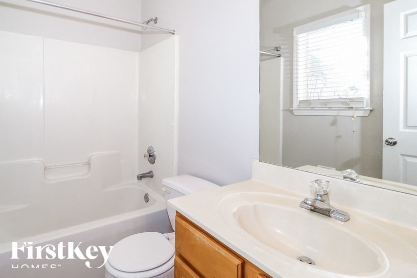 A white bathroom with a tub, toilet and sink.
