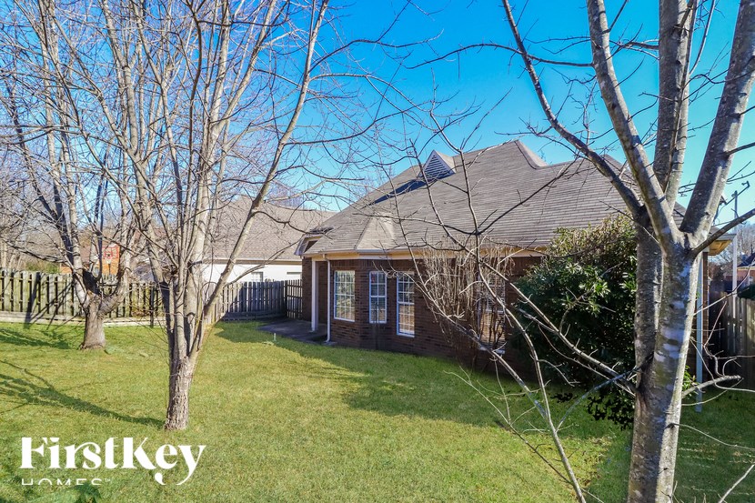 A house with a lawn and trees in front of it.