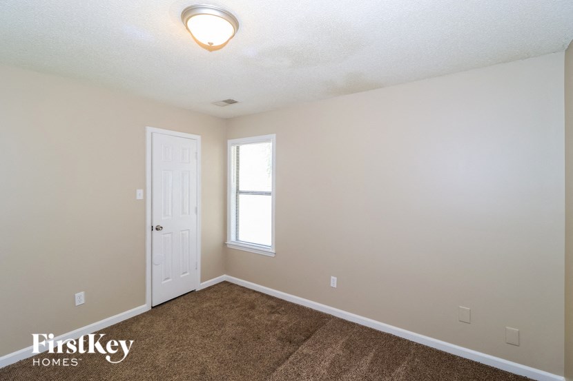 the upstairs bedroom with carpet and a door to the bathroom