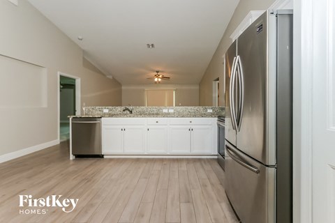 A kitchen with a refrigerator on the right side.