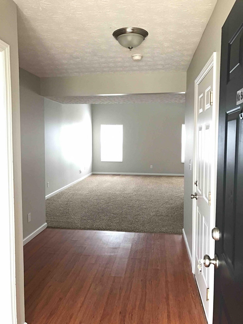 an empty living room with wood floors and a door