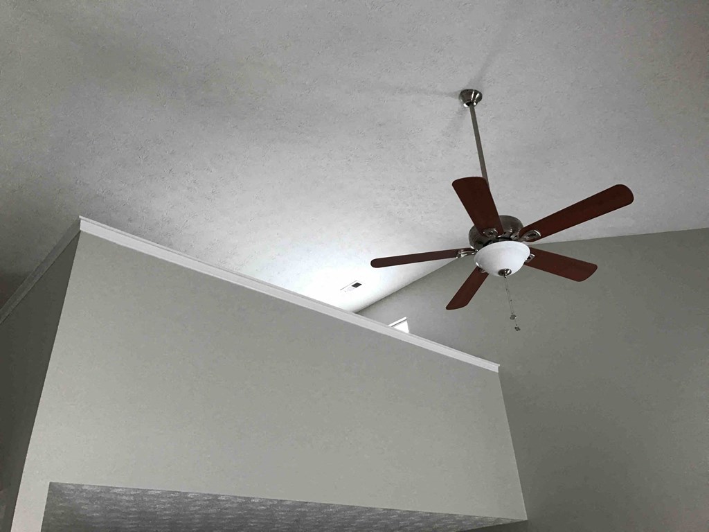 a ceiling fan hanging from a ceiling next to a staircase