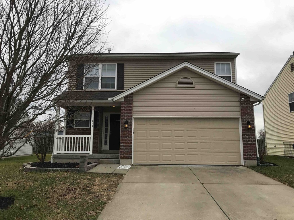 the front of a house with a driveway and a garage door