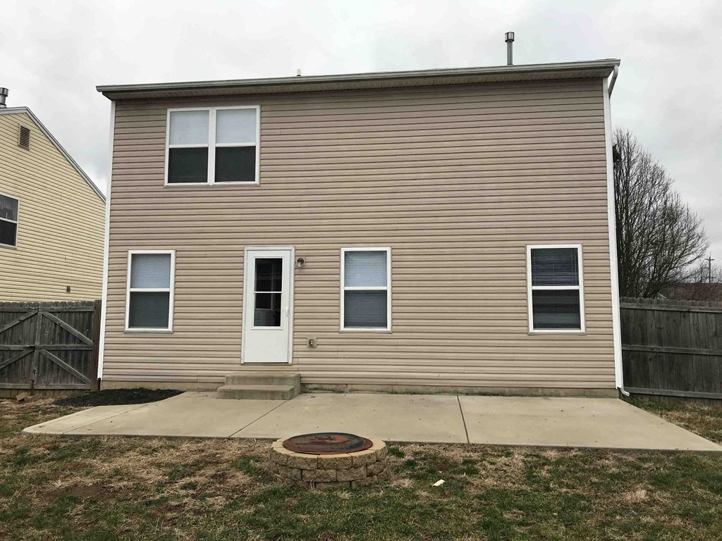 a brown house with a white door and a sidewalk