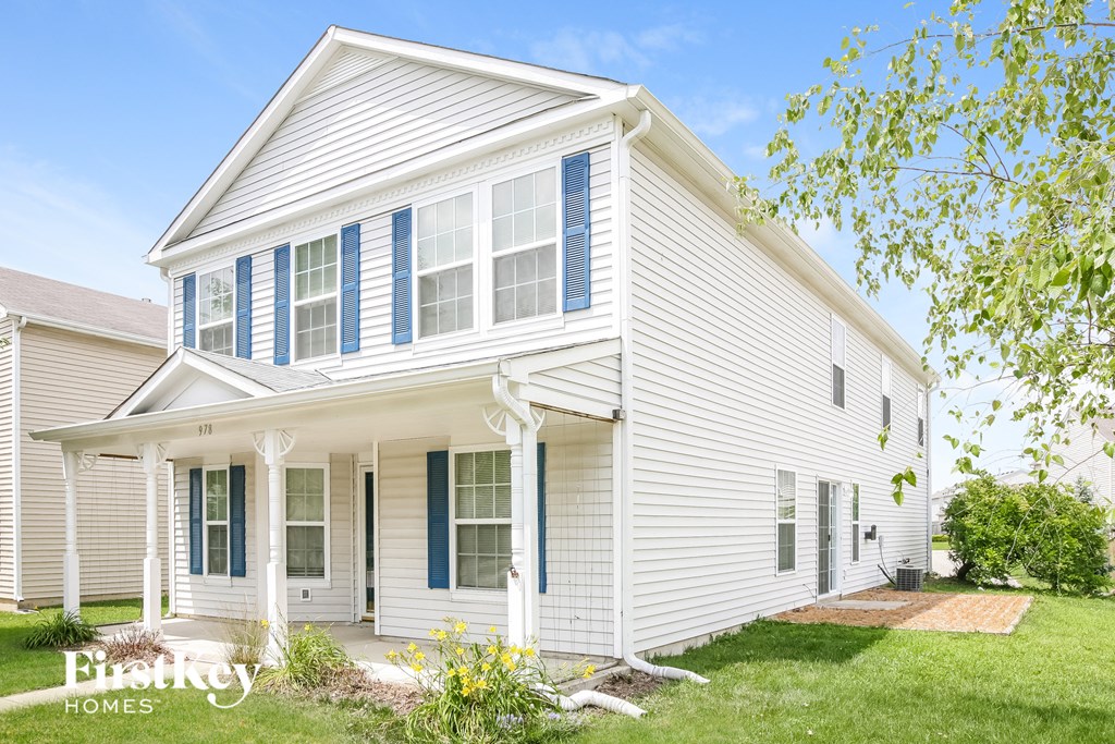 A white house with blue shutters and a porch.