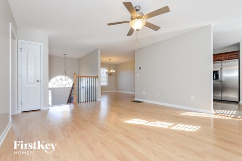 A spacious room with a ceiling fan and wooden flooring.