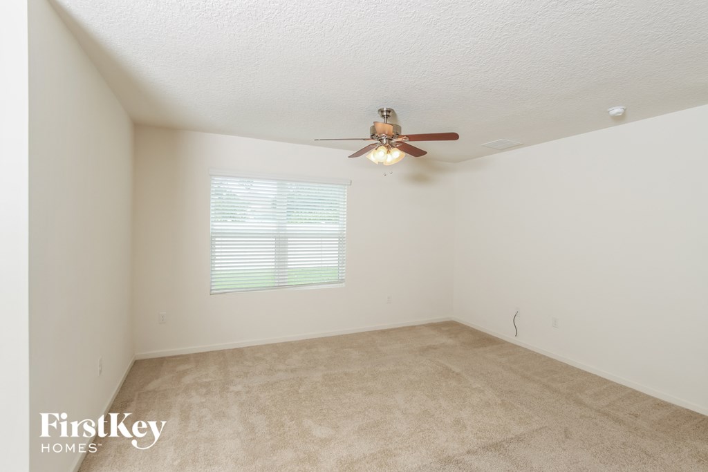 a bedroom with a ceiling fan and a carpeted floor