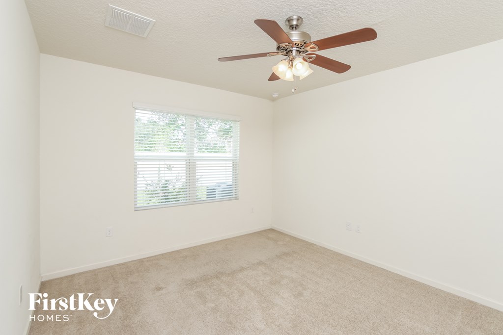 a bedroom with a ceiling fan and a window