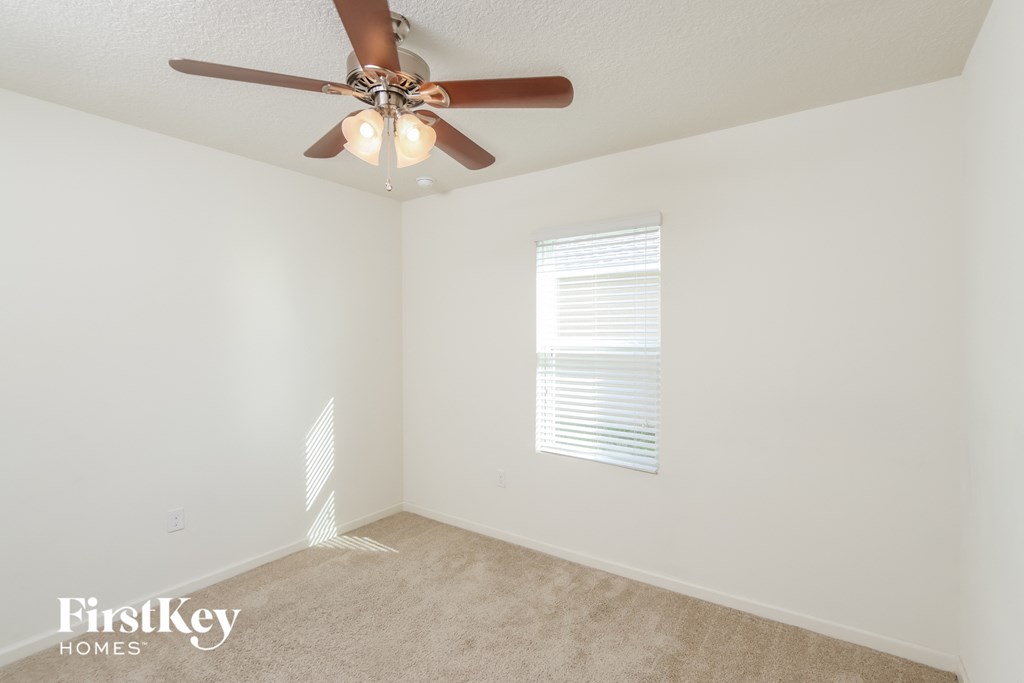 a bedroom with a ceiling fan and a window
