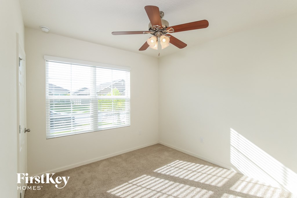 a bedroom with a ceiling fan and a window