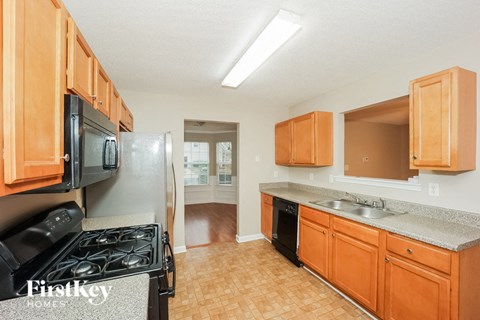 A kitchen with wooden cabinets and a black stove top oven.