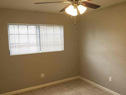 a bedroom with a ceiling fan and a window