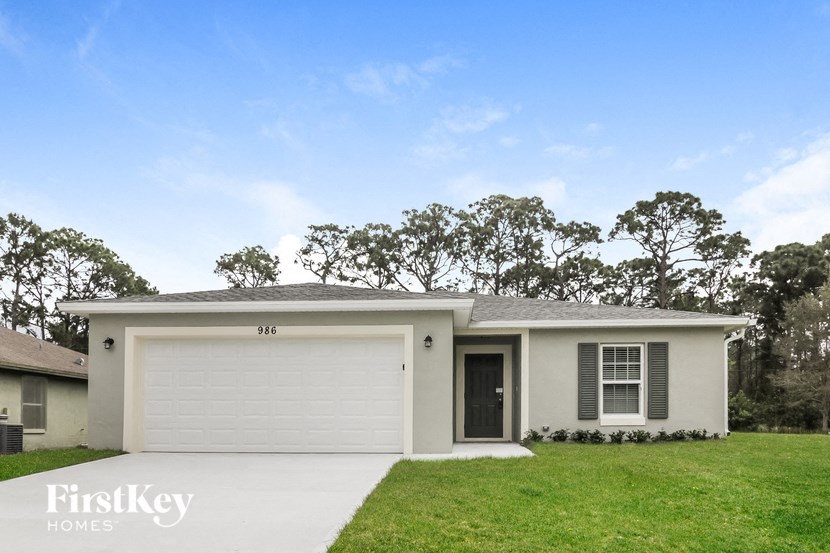 a white house with a lawn and a garage door