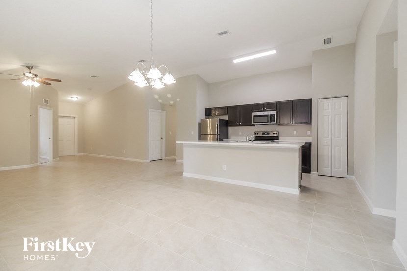 an empty living room and kitchen with a counter top and